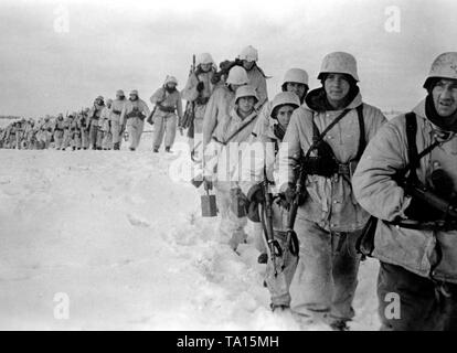 Im Winter defensive Kämpfe an der Ostfront, Deutsche Soldaten März über einem schneebedeckten Feld. Foto der Propaganda Firma (PK): kriegsberichterstatter Wacker. Stockfoto