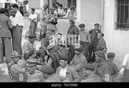 Die französischen Soldaten kümmern sich um eine Gruppe von Spaniern (sitzend, in Decken mit den baskischen Kappen verpackt, teils in der Uniform der Spanischen Armee), die zuvor von den Truppen des General Franco geflohen, in dem kleinen französischen Pyrenäenstadt St-Jean-Pied-de-Port, Aquitaine im September 1936. San Sebastian wurde durch die Invasion der Nationalisten, die bereits im Juli. Stockfoto