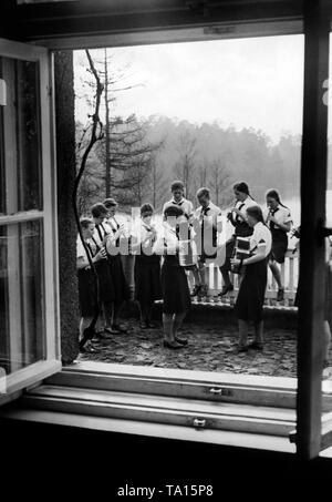 BDM-Mädchen spielen Flöte und Akkordeon auf dem Balkon während Ihres Aufenthaltes in der Jugendherberge Prebelow (Jugendherberge) in der Nähe von Rheinsberg. Im Hintergrund die gröberen Prebelowsee. Stockfoto