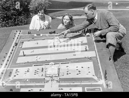 Dudley M. Steele, Vorsitzender des Nationalen Air Race-Ausschuss - zeigt zwei junge Frauen (Janet McDowell und Nancy Nash) ein Modell eines Air racing Veranstaltungsort. Stockfoto