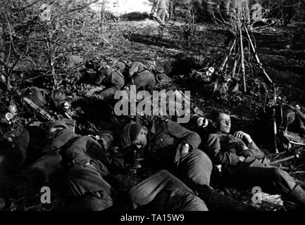 Schlafen Deutsche Infanteristen auf dem donetz. Ihre Gewehre lehnen sich gegen Bush im Hintergrund. Kriegsberichterstatter: Kipper. Stockfoto