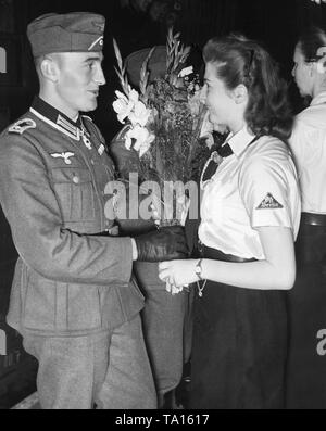Ein BDM Führer übergibt einen Blumenstrauß für eine zurückgegebene Soldat aus der Krim, die das Ritterkreuz ausgezeichnet wurde. Stockfoto