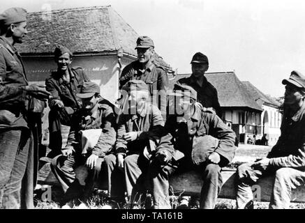 Deutsche Soldaten haben ein Gespräch in einem Dorf in den Karpaten. Vermutlich sind Sie Männer, die zuvor von der Roten Armee gefangen genommen wurden, und sie schafften es, zu entkommen. Foto der Propaganda Firma (PK): Kriegsberichterstatter Waidelich. Stockfoto