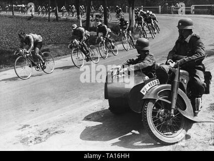 In der Phase "Chemnitz-Erfurt am 8. Juni 1937, die dritte Etappe der Tour von Deutschland, dem wichtigsten Bereich der Radfahrer übergibt zwei Motorradfahrer der Wehrmacht. Stockfoto