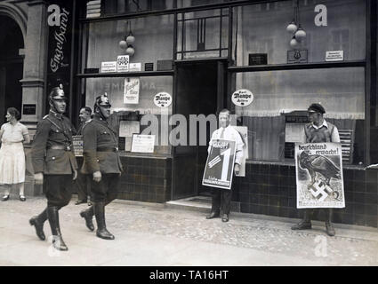 Polizeistreifen sichert ein Wahllokal in Berlin anlässlich der Reichstag die Wahl. Plakat Träger der SPD und NSDAP stehen vor dem Gebäude. Die SPD-Kampagnen mit "Freiheit!", und die NSDAP Nachfragen "Wake up Deutschland!" Auf der linken Seite im Hintergrund Es gibt einen Mann, der sich für die Politiker Heinrich Bruening. Stockfoto