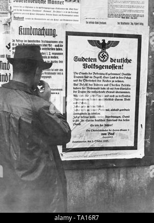 Nach dem Münchener Abkommen im Oktober 1938, in der Tschechoslowakei hatten die Sudetendeutschen Gebiete an das Deutsche Reich abtreten. Ein Mann liest eine Ankündigung von Adolf Hitler die Sudetendeutsche Bevölkerung. Stockfoto