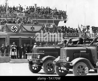 Foto der Deutschen militärischen Fahrzeugen der Legion Condor während einer Siegesparade für General Francisco Franco am Flughafen Madrid Barajas, nach dem Einmarsch der Stadt am 28. März 1939. Im Hintergrund, der Terminal des Flughafens, die in eine Tribüne gedreht wurde, mit der VIP stehen für Franco (begrüßt mit angehobenem Arm). Darunter, eine Hakenkreuzfahne und die Trikolore (Flagge des Königreichs Italien) hängen neben der Spanischen Bandera. Stockfoto