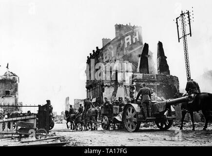 Geschleppt, die deutsche Artillerie kreuzt ein zerstörtes Dorf Französisch während der Offensive im Westen. Die Waffe ist wahrscheinlich ein Feld Haubitze vom Typ '15 cm schwere Feldhaubitze 18'. Stockfoto