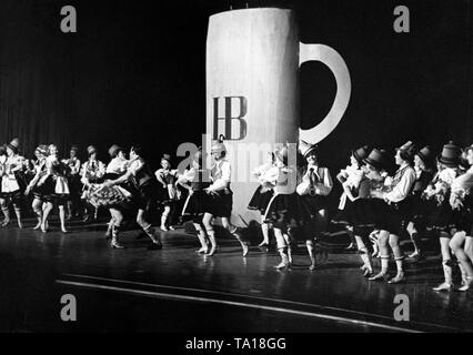 Die Weltpremiere der KdF-Show "Freut euch des Lebens"' ist im "Theater des Volkes" in Berlin statt, zu dem auch eine Szene eines bayerischen Ballett um einen überdimensionalen Bierkrug Der Hofbräuhaus München. Stockfoto