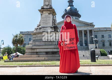 Columbia, South Carolina USA - Mai 21, 2019: Aktivist R.M. trägt ein Kostüm Outfit, das ähnelt dem der Zeichen aus der Show' des Handsmaid Erzählung "während Sie ein Schild mit der Aufschrift "Die Gebärmutter ist nicht Eigenschaft State' während der top Rally das South Carolina der Verbot". Top Die Verbote" Kundgebungen fanden in allen 50 Staaten der USA heute als direkten Widerstand gegen die wachsende konservative Versuch Roe vs zu kippen. Wade und das Recht der Frau eine legale und sichere Abtreibung entfernen. Credit: Crush Rush/Alamy leben Nachrichten Stockfoto