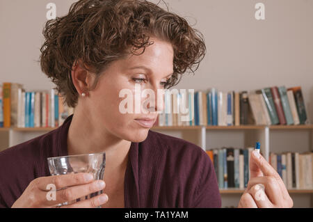 Junge Frau über die Pille besorgt Stockfoto