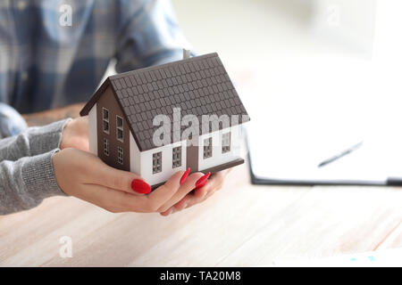 Paar hält Abbildung des Hauses. Sachversicherung Konzept Stockfoto