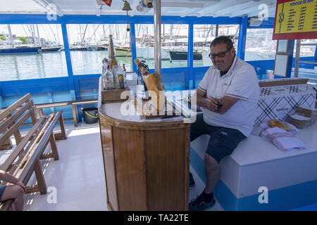 PALMA, MALLORCA, SPANIEN - 20. MAI 2019: Schinken schneiden von synthetischen jamonero auf Tour Boot am 20. Mai 2019 im Palma, Mallorca, Balearen, Spanien. Stockfoto