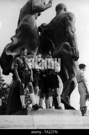 Eine Gruppe von Teenagern in HJ-Uniformen Pose vor dem Deutschen Pavillon auf der Pariser Weltausstellung vor einer monumentalen Statue durch den Bildhauer Josef Thorak. Stockfoto