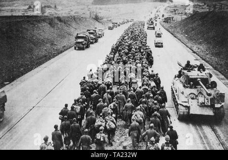 Soldaten der Deutschen Wehrmacht pass vorrückenden amerikanischen Truppen in ihren Weg in die Kriegsgefangenschaft. Die Gefangenen marschieren auf dem Mittelstreifen der Autobahn in der Nähe der Stadt Gießen. Stockfoto