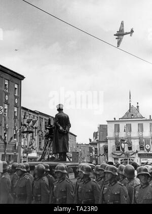 Ein Flugzeug der Luftwaffe vom Typ Junkers Ju 52 über die Stadt Jaegerndorf (heute Krnov) am 7. Oktober 1938, während der Besetzung des Sudetenlandes durch Deutschland. Auf der linken Seite, ein Foto Journalist mit einer Filmkamera (Wochenschau - Wöchentliche Überprüfung). Stockfoto