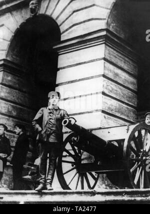 Ein Soldat mit einer Kanone vor dem Smolny Institut, das als Sitz des Petrograder Sowjet unter der Führung von Lenin während der Oktoberrevolution serviert. Stockfoto