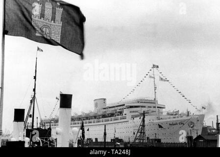 Blick auf das Kreuzfahrtschiff "Robert Ley" von der NS-Organisation "Kraft durch Freude" ('Stärke durch Freude') im Hamburger Hafen. Im Vordergrund eine Flagge mit dem Wappen von Hamburg. Stockfoto