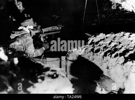 Ein Soldat steht Wache auf einem MG 42 auf eine Pistole Schlitten in eine Position in der Prinsk Sümpfe montiert. Er trägt eine Tarnung uniform. Foto: kriegsberichterstatter Etzold Stockfoto