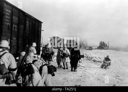 In der zweiten Schlacht von Ladoga, Es gab Kämpfe für ein güterbahnhof (vermutlich aus Pogoste). Deutsche Soldaten im Winter camouflage beachten Sie die feindliche Stellungen neben einem Güterwagen. Foto der Propaganda Firma (PK): kriegsberichterstatter Slapak. Stockfoto