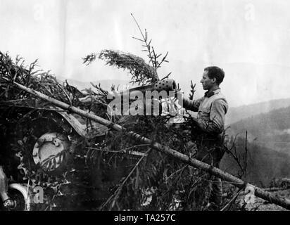 Ein Soldat steuert eine artilleriegeschützen (43M Zrinyi) getarnt durch Niederlassungen auf einem Pass in den Östlichen Karpaten. Foto der Propaganda Firma (PK): kriegsberichterstatter Brantenberg. Stockfoto