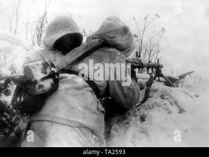 Soldaten der SS in einer verschneiten Bekämpfung stehen an der Ostfront im Winter defensive Schlacht von 1943. Im Winter Tarnung Bekleidung Sie wollen mit einem Maschinengewehr 34 auf den Feind. Foto der Propaganda Firma (PK): SS Kriegsberichterstatter Fritsch. Stockfoto