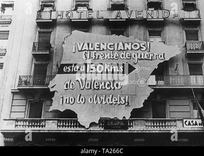Foto einer Propaganda Plakat der republikanischen Regierung in Form einer Karte von Spanien auf der Fassade des Hotel Avenida in Valencia. Inschrift: Valencia. Die Schlacht ist nur 150 km von Valencia entfernt. Tun sie es nicht vergessen! Teruel gekennzeichnet ist. Stockfoto