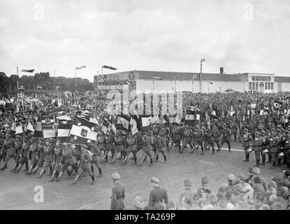 Mitglieder des Stahlhelm März mit Fahnen und Uniformen, bevor ihre Führer, eine Band auf der rechten Seite ist sie zu begleiten. Im Hintergrund, die Junkers Flugzeug- und Motorenwerke. Stockfoto