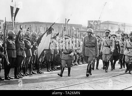 10.000 italienischen Soldaten, die als freiwillige Helfer an der Seite der Franco Truppen im Spanischen Bürgerkrieg gekämpft, sind in den Hafen von Neapel am 21. Oktober 1938 erhalten. Von links nach rechts: König Victor Emmanuel III. von Italien, der Kommandant der Legion von General Mario Berti (mit stahlhelm), Kronprinz Umberto von Savoyen (1946, als Umberto II letzte König von Italien), Gian Galeazzo Ciano (Mussolini's Schwiegervater, Außenminister). Auf der linken Seite, Soldaten begrüssen das Empfangskomitee mit einem Standard. Stockfoto