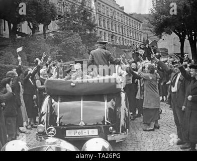 Reich der Innenminister Wilhelm Frick visits Joachimsthal (Jachymov) am 18. Oktober 1938. Er grüßt Menschen in einem fahrenden Auto stehen. Stockfoto