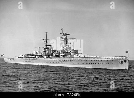 Foto der Schwere Kreuzer 'Deutschland' in einem stürmischen Meer vor 1935. Die Mannschaft hat bis auf das Deck gesäumt. Am Bug und am Heck sind die beiden Revolver mit sechs 28 cm automatische Waffen. Am Bug und am Heck des Naval Fähnriche (GOESCH) des Deutschen Reiches (1933-1935) noch Blasen werden ohne das Hakenkreuz. Stockfoto