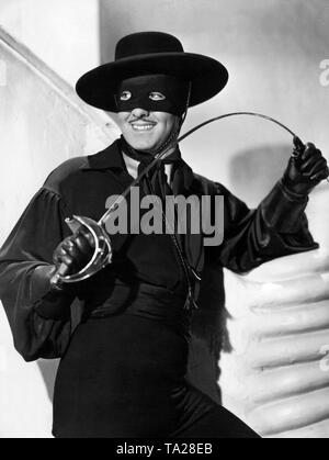 Tyrone Power als Don Diego mit Schwert, Maske und Cape in dem Film "Im Zeichen des Zorro". Stockfoto