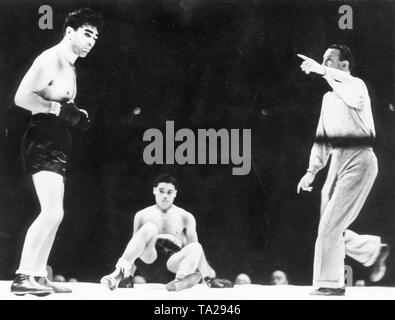 Deutscher Boxer Max Schmeling (rechts) gegen den Amerikaner Joe Louis an der Meisterschaft Spiel im Yankee Stadium in New York, die am 19. Juni. 1936. Boxing Schiedsrichter Arthur Donovan sendet Schmeling (links) zurück in seine Ecke Stockfoto