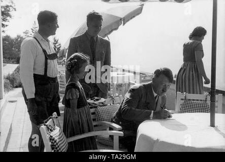 Adolf Hitler gibt ein Mädchen ein auf der Terrasse des Berghof auf dem Obersalzberg Autogramm. Stockfoto