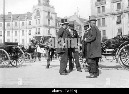 Kutscher sprechen vor ihre Kabinen auf dem Karlsplatz Stachus im Zentrum von München. Das Foto wurde im frühen 20. Jahrhundert genommen (vor 1914). Stockfoto