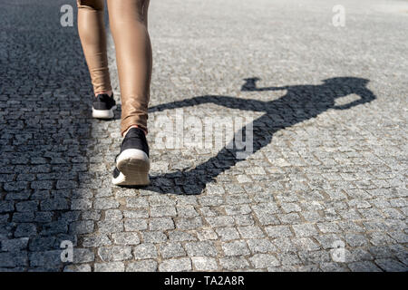 Nahaufnahme der Frau Schuhe mit Schatten auf Kopfsteinpflaster Stockfoto