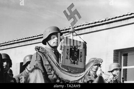 Foto von einem Mitglied der Militärmusik der Legion Condor Holding einen türkischen Halbmond (verziert mit einem Hakenkreuz und dem Spanischen Nationalen Emblem) während der Parade anlässlich der Feier Tag der Luftwaffe auf dem Flugplatz von Saragossa, Aragon am März 1st, 1939. Stockfoto