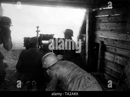 Deutsche Soldaten das Feuer mit einem 7,5 cm beiden infanteriegeschütz 18 aus einer Holz- Bunker. Der Shooter soll mit Hilfe eines Teleskops (ZE34). Foto der Propaganda Firma (PK): kriegsberichterstatter Schuerer. Stockfoto