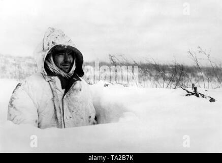 Ein Soldat der Wehrmacht beobachtet die Don vorne von einem foxhole fast vollständig von Schnee trieb. Foto der Propaganda Firma (PK): kriegsberichterstatter Grimm-Kastein. Stockfoto