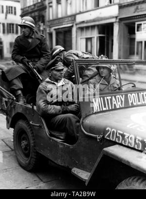 Das amerikanische Militär Polizisten nehmen den Offizier Henke in Ihren Jeep, die entlang der Autobahn Ansbach zusammen mit etwa 100 anderen deutschen Soldaten gefangen genommen wurde. Stockfoto