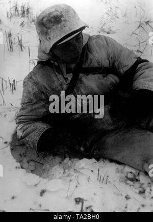 Ein deutscher Soldat tragen Winter camouflage liegt im Schnee südöstlich der Stadt Toropez. Foto der Propaganda Firma (PK): SS Kriegsberichterstatter Tufts. Stockfoto