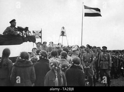 Der Führer der "tahlhelm, Bund der Frontsoldaten" hält eine Rede an die Männer, die ausgemustert wurden, sowie zu BDM-Mädchen mit den floralen Kränze, während einer März in Wittenberg (Prignitz). 2. von rechts: Wilhelm, Deutscher Kronprinz. Auf der linken Seite hinter dem Rednerpult, eine Flagge des Stahlhelm Gau Stuttgart. Stockfoto