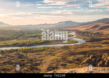 Die schöne Landschaft in der Abendsonne. Mtkvari River auf dem Hintergrund des Kaukasus, am Ufer des Flusses Ruinen einer mittelalterlichen Stockfoto