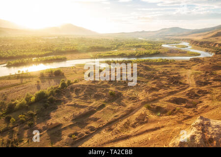 Schöne Landschaft im Sonnenlicht. Mtkvari River auf dem Hintergrund des Kaukasus, am Ufer des Flusses Ruinen einer mittelalterlichen Sett Stockfoto