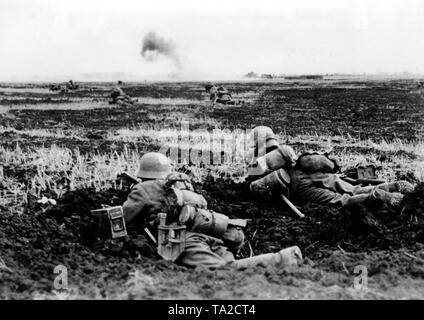 Deutsche Infanteristen liegen in Position während der Kämpfe im offenen Feld am Donez vorne. Rauch steigt in den Hintergrund. Kriegsberichterstatter: Herber. Stockfoto