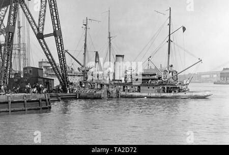 Der Schlepper "Tuka' zieht ein Ponton mit Aufbauten dem gesunkenen U-Boot S-4 zu retten. Stockfoto