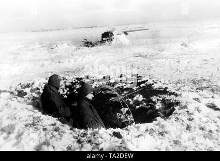 Zwei Soldaten mit MGs 34 ein Gewehr 98 (Mauser Modell 98) sichern eine 7,5 cm Flak aus einer Schlacht. Foto der Propaganda Firma (PK): kriegsberichterstatter Schoedel. Stockfoto