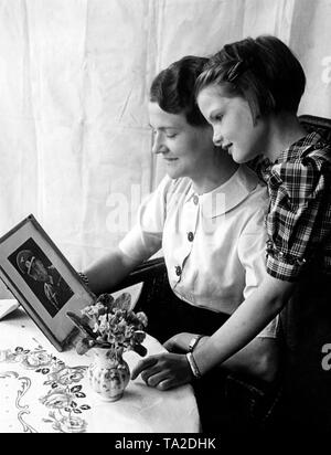 Viele Fotos wurden von der Presse am Tag des ersten Mutter im Krieg, die Harmonie zu veranschaulichen veröffentlicht. Foto von einer Mutter und ihrer Tochter mit dem Bild des Vaters, der als Soldat der Wehrmacht auf der Vorderseite. Stockfoto