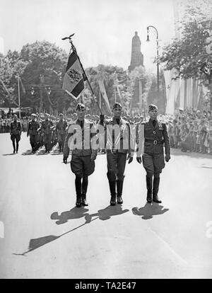 Foto Farbe Wachen der Legion Condor während der siegesparade der Legion in Hamburg am 30. Mai 1939. Die Farben (Spanisch bandera) wird von einem Corporal mit Schwert Knoten durchgeführt. Auf der rechten und auf der linken Seite, Offiziere. Im Hintergrund, die Bismarck Denkmal im Alten Elbpark am Millerntorplatz. Stockfoto