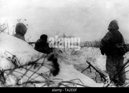 Drei Soldaten eines SS-trooper Einheit an einem unbekannten Ort an der Ostfront. Bewaffnet mit Maschinengewehr 34, haben sich in einem Schnee hohl. Foto der Propaganda Firma (PK): kriegsberichterstatter Fritsch. Stockfoto